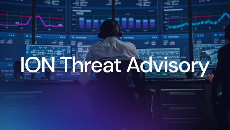 A person viewed from behind, wearing headphones, sitting at a desk with multiple computer screens displaying data and graphs, with the text "ION Threat Advisory" prominently shown in white.