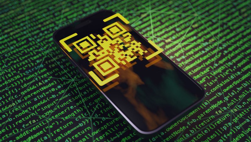 A smartphone displaying a yellow QR code on its screen, set against a green background with binary code patterns. The image suggests themes of technology and security, relating to the message 'QR Phishing is on the Rise.'