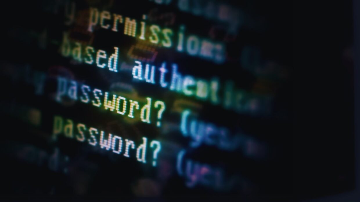 Close-up of a computer screen displaying lines of code related to authentication, including the word 'password?' indicating user input requirements. The image relates to topics like Adversary-in-the-middle Attacks.