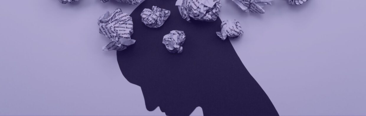 A silhouette of a person's head in profile against a pale purple background, with crumpled pieces of paper floating above, symbolizing thoughts or stress. The image relates to themes of mental well-being and addresses Combating SOC Burnout.