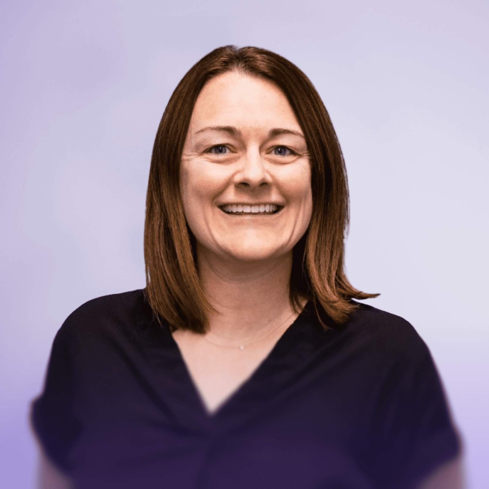 Kate Montgomery, wearing a black blouse, smiling at the camera in a modern office setting with blurred lights in the background.